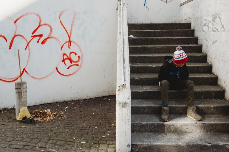 boy sitting on steps in Reykjavik Iceland 