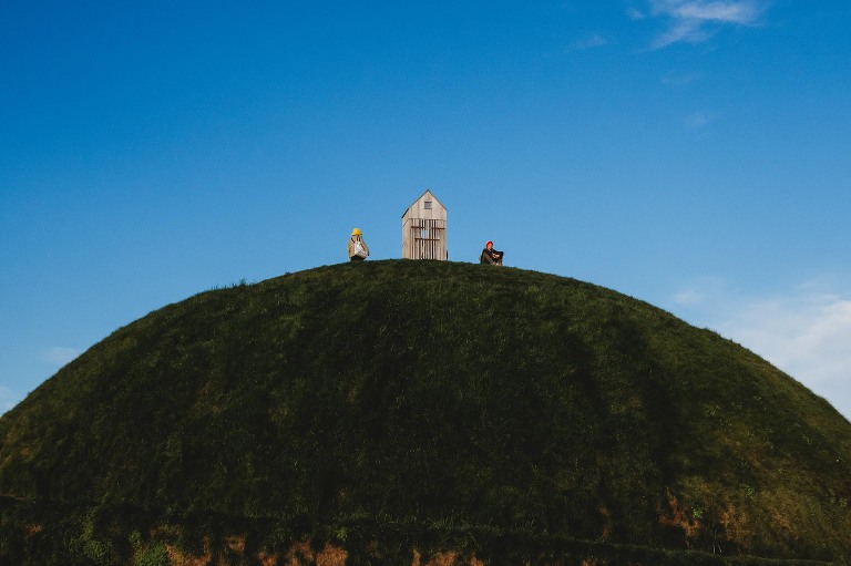 Boy sitting on grassy hill in reykjavik harbor fishermen memorial 