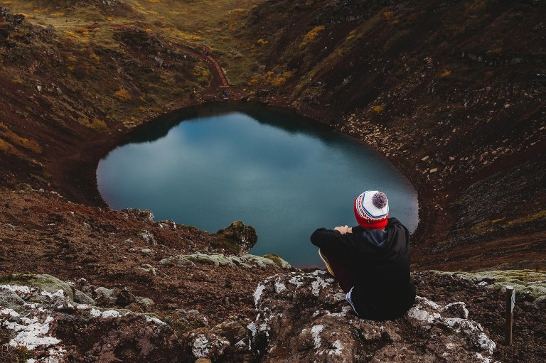boy staring down at Kerid crater Golden Circle Iceland
