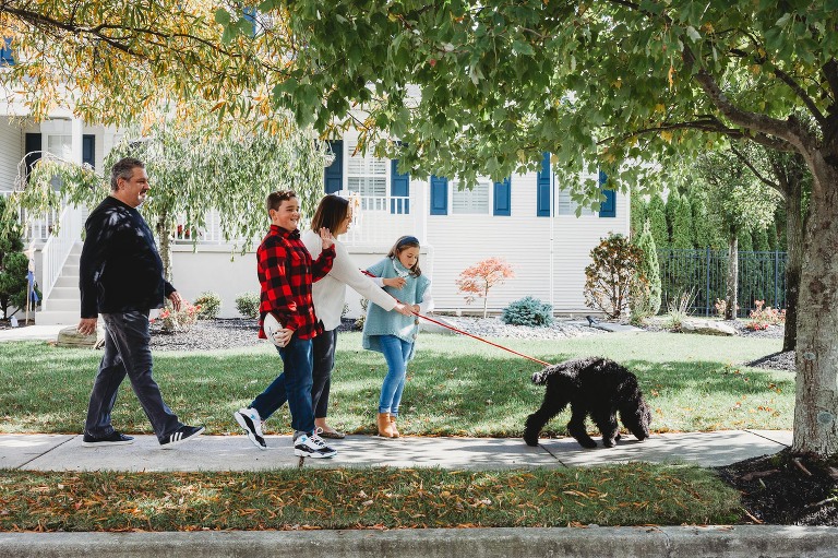 Family walking dog in neighborhood