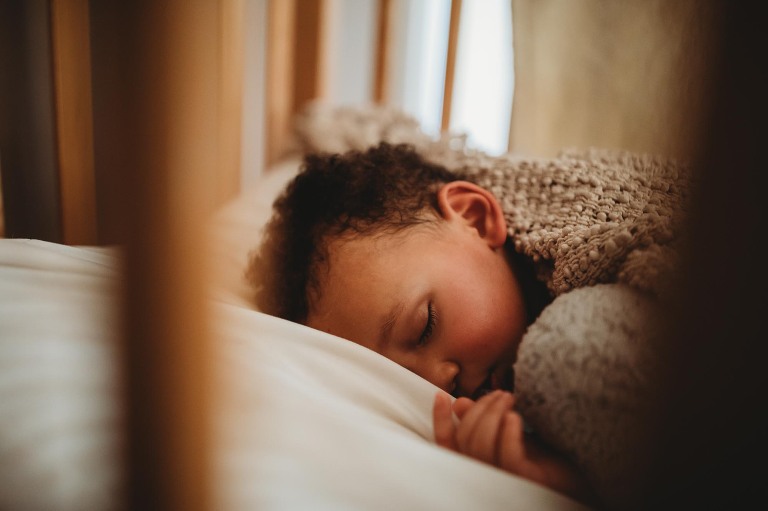 Baby boy napping in crib