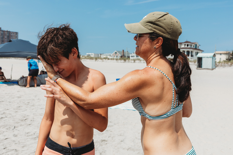 mom putting sunscreen on oldest son