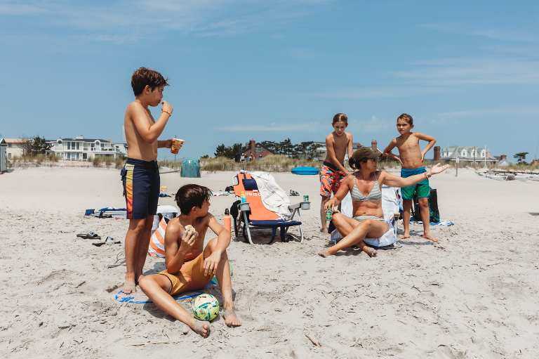 mom with sons at the beach playing soccer and eating ice cream