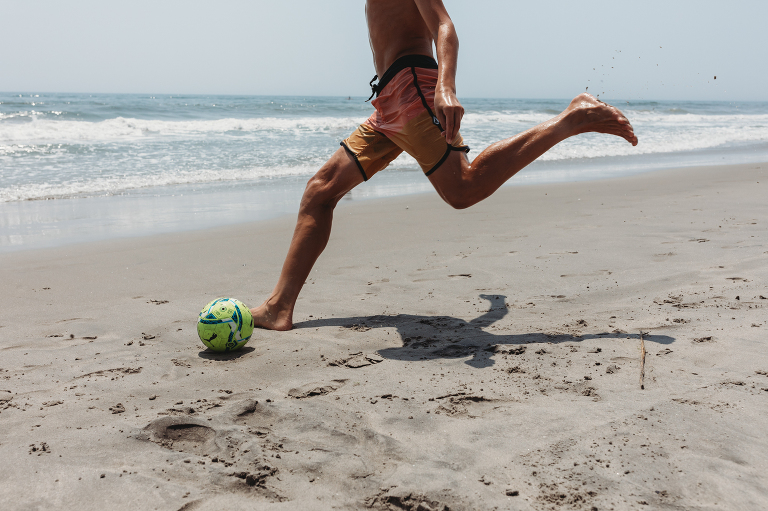 playing soccer on the beach