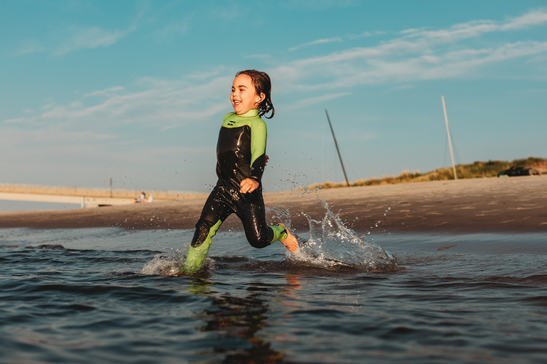 boy wearing wetsuit and jumping into the bay ocnj
