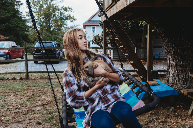 girl on swing with pet bunny