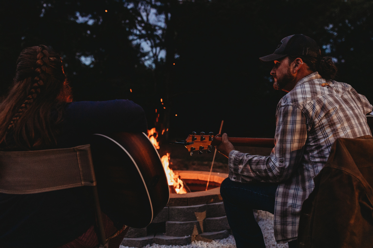 family playing guitar around a campfire