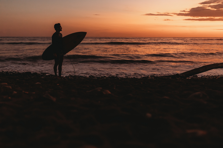 surfer at sunset in Playa Dominical Costa Rica